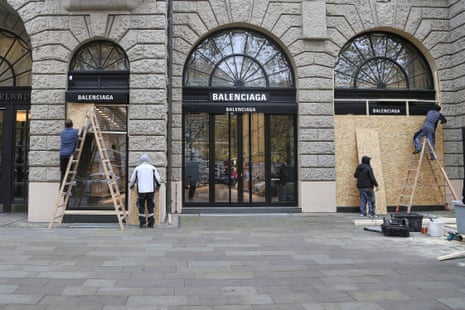 Workers boarding up a storefront.
