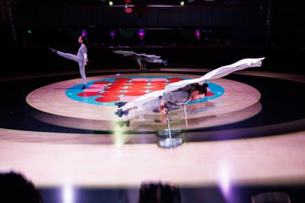 two people dance on roller skates while wearing parachutes while another person