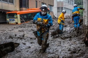 Shizuoka, Japan: A police officer with a search-and-rescue dog examines the area around the site of a landslide in Atami.