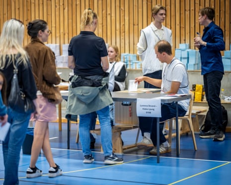 Voters queue to cast ballots at a polling station in a sports hall during Sweden's general election in Lomma, southern Sweden.