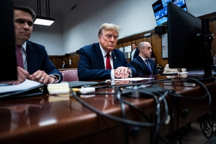 Donald Trump sits at a table with two other men