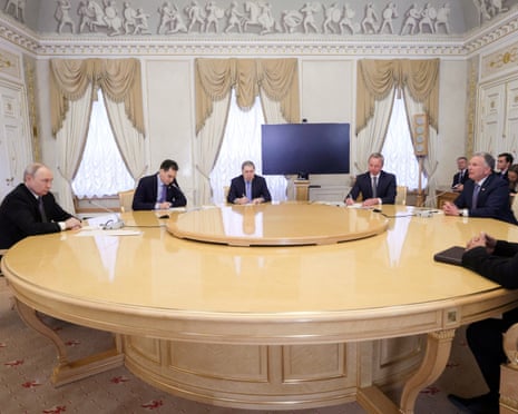 Putin, Witkoff and officials sit around an oval table in an ornate palace room