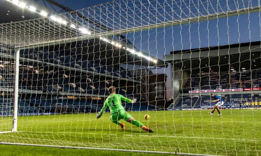 St Johnstone’s Zander Clark saves a penalty from the Rangers striker Kemar Roofe by diving to his left