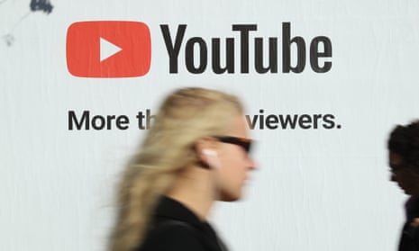 A woman walks past a billboard advertisement for YouTube