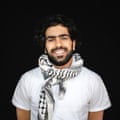 Ahmed Alghariz smiling, wearing a white T-shirt and keffiyeh