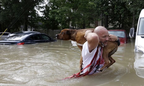 Louis Marquez carries Dallas, his dog, through floods.