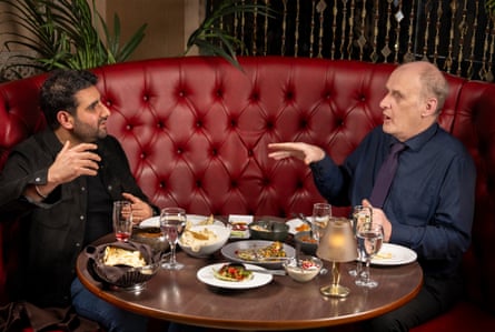 Two men facing each other at a restaurant table
