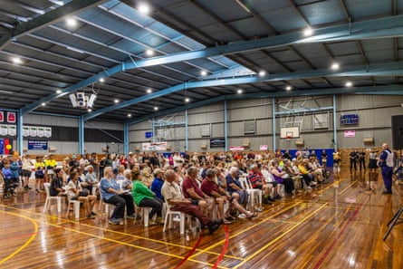 Group of people at disaster relief centre listening to a man speak