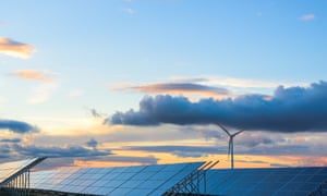 Solar panels and wind turbine at sunset