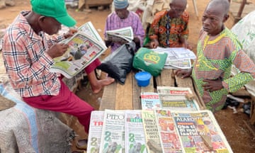 People reading newspapers at a street stall