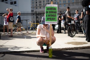 An abortion rights demonstrator bows down as people protest the supreme court’s decision in Detroit.
