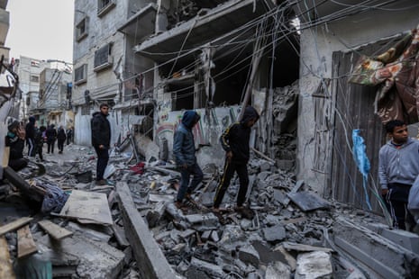 People inspect damage to their homes caused by Israeli airstrikes on 17 January 2024 in Rafah.