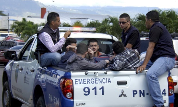 Policemen escort five Syrian men after they were detained at Toncontin international airport in Tegucigalpa, Honduras.