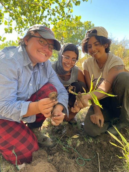 Farmers Anita Adalja, center, Antonia Ruiz, left, and Mallika Singh, right, holding ginger at Ashokra farm in Albuquerque, New Mexico.