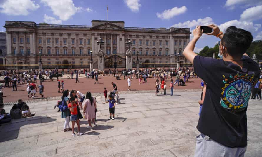A man takes a picture of Buckingham Palace, in London, Saturday, June 5, 2021