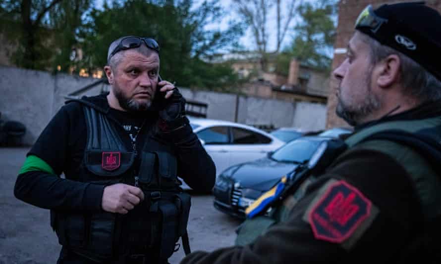 Talking on phone, looking surprised, heavily armed.