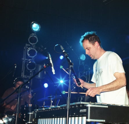 Bitney leaning over a drum machine highlighted by lights