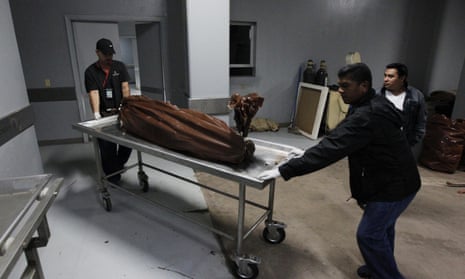 Technicians wheel a stretcher with a body bag, containing the body of a young man who was shot by members of street gang Mara 18 for attempting to steal a motorcycle, at a morgue in Tegucigalpa, Honduras.
