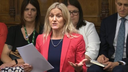 Kim Leadbeater speaks in the House of Commons. She has long, loose, wavy blond hair and wears a red jacket over a black top.