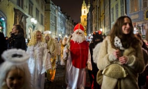 A man dressed as St. Nicholas, accompanied by angels and devils, walks through city centre on December 5, 2014 in Prague, Czech Republic.