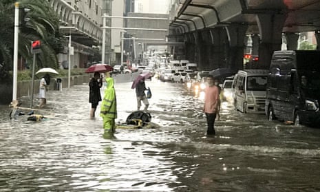 Vehicles and pedestrians on a flooded road in Wuhan