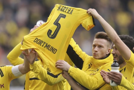 Dortmund players hold up the No 5 shirt of teammate Marc Bartra after a match between Borussia Dortmund and Eintracht Frankfurt on Saturday. Bartra was seriously injured in the bomb attack on Dortmund’s bus on 11 April.