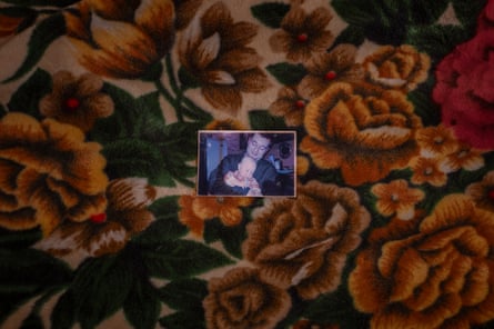 A photo of Olha’s dead husband and child on a floral bedspread