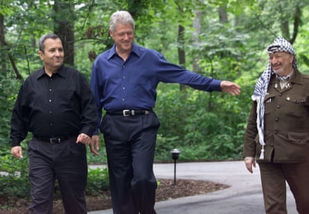 Three men walk on a wooded street