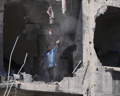 A resident reacts as she retrieves belongings from her apartment in a building damaged in Israeli strikes in the southern port city of Tyre, Lebanon.