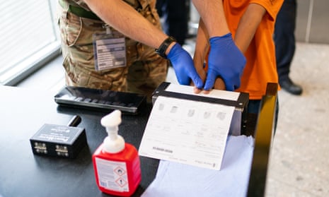 A refugee has their fingerprint taken at Heathrow airport