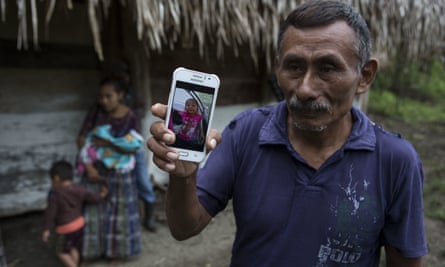 Domingo Caal, 61, holds a smartphone displaying a photo of his granddaughter Jakelin.