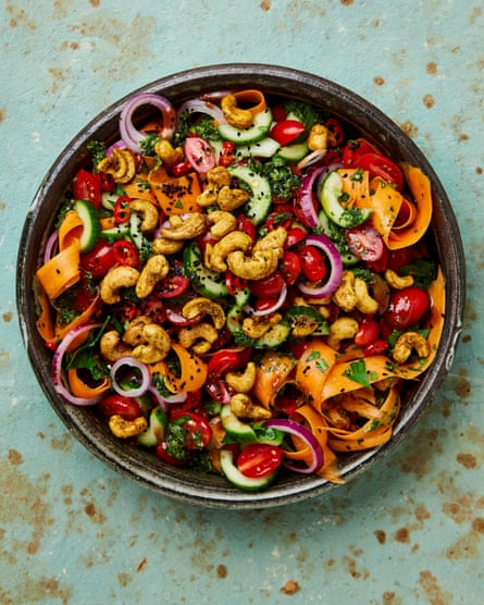 Cucumber salad with cashews, tomatoes, carrots, herbs and red onions.