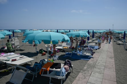 A beach with rows of parasols and sun loungers
