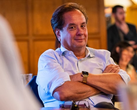 a man sits at a table with his arms crossed