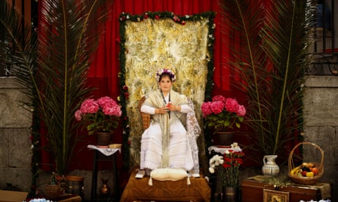 A 'Maya' girl sits on an altar during the traditional celebration of 'Las Mayas' on the streets of the small village of Colmenar Viejo.