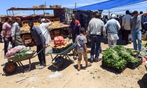 Libyans shop for vegetables at an open-air market in Tripoli.