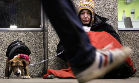 Dawn, a homeless woman from north Wales, sits huddled under a sleeping bag next to her dog in London