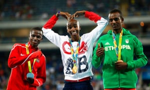 Mo Farah celebrates on the podium with second placed Paul Kipngetich Tanui (left) of Kenya and third-placed Tamirat Tola of Ethiopia.