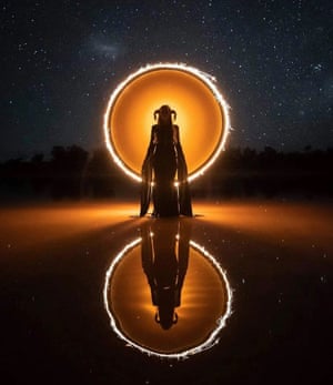 A woman in front of a round light