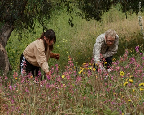 two people picking up invasive grass and black mustard in a park