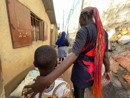 Florence Lugemwa walks the children home after band practice.