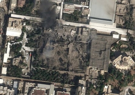 Satellite image of an apparently bombed compound surrounded by standing buildings