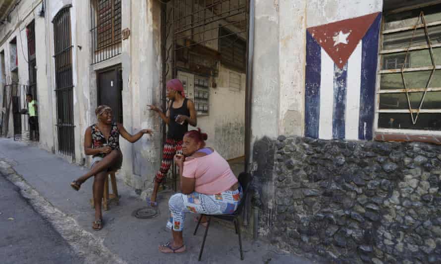 Women chat on the sidewalk in Havana
