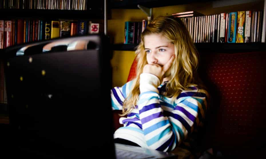 Teenage girl using a laptop computer at home.