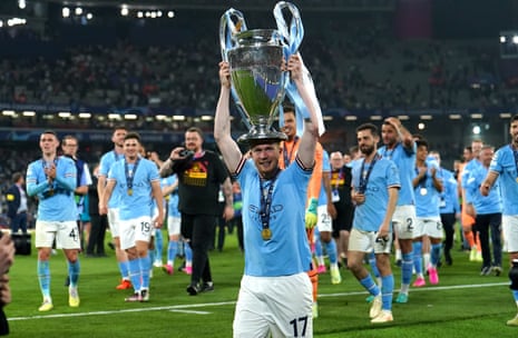 Kevin De Bruyne holds the Champions League trophy aloft