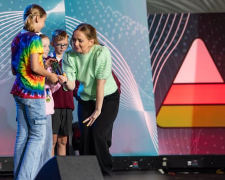An adult with children on stage