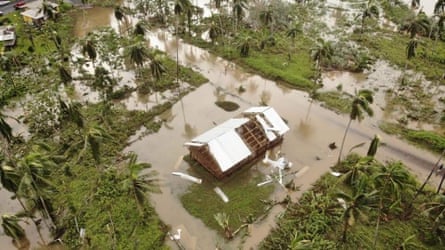 Damaged house surrounded by flood waters