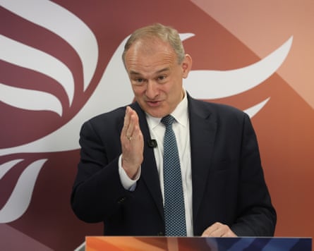 Ed Davey at podium with hand in air