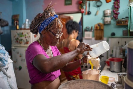 In her kitchen, a woman filters water intended for drinking after boiling it