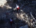 emergency workers walk among the rubble of a destroyed synagogue